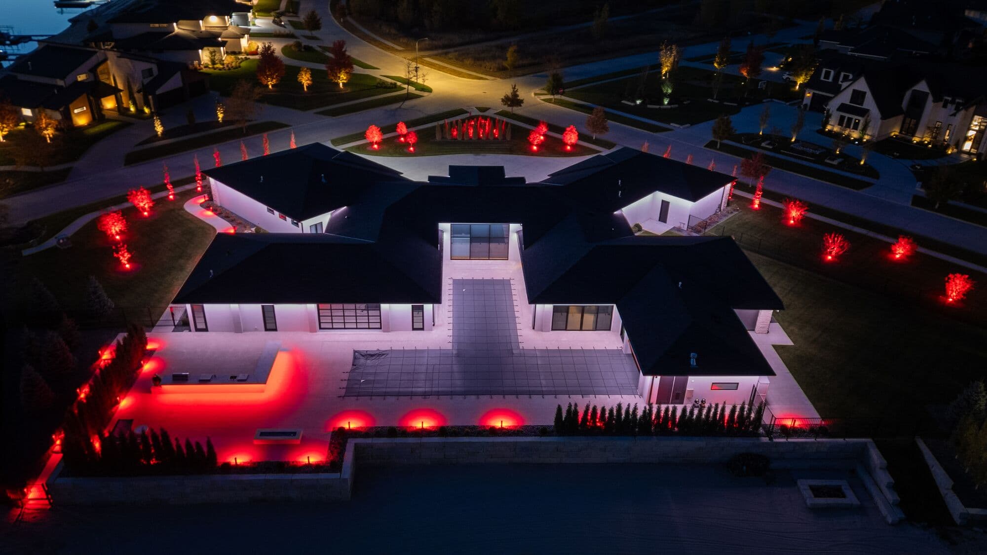 An Omaha home photographed from above at night, the red runs tracing every ridge and valley of the roof