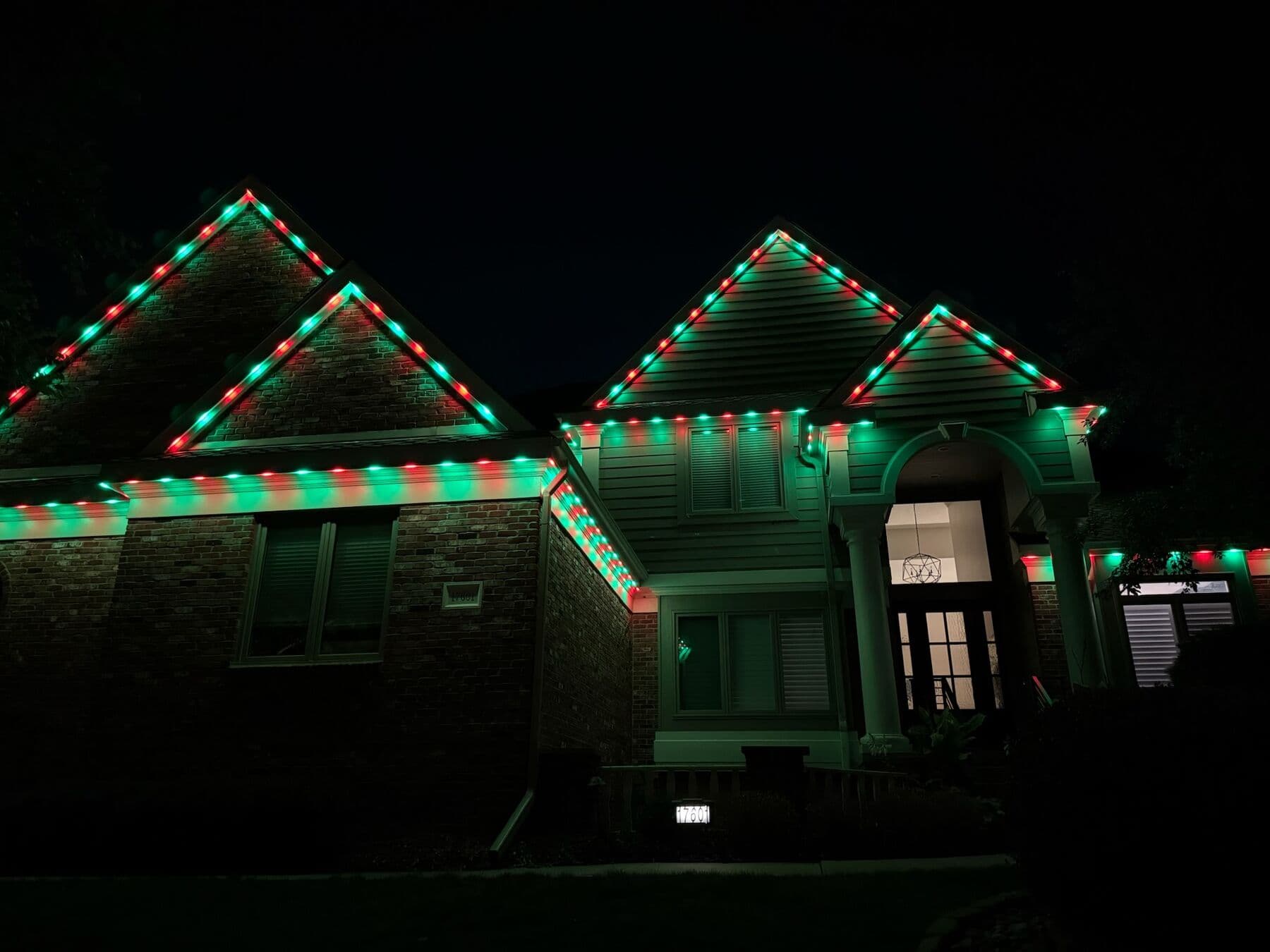 Alternating red and green along every gable and eave of a brick Omaha home
