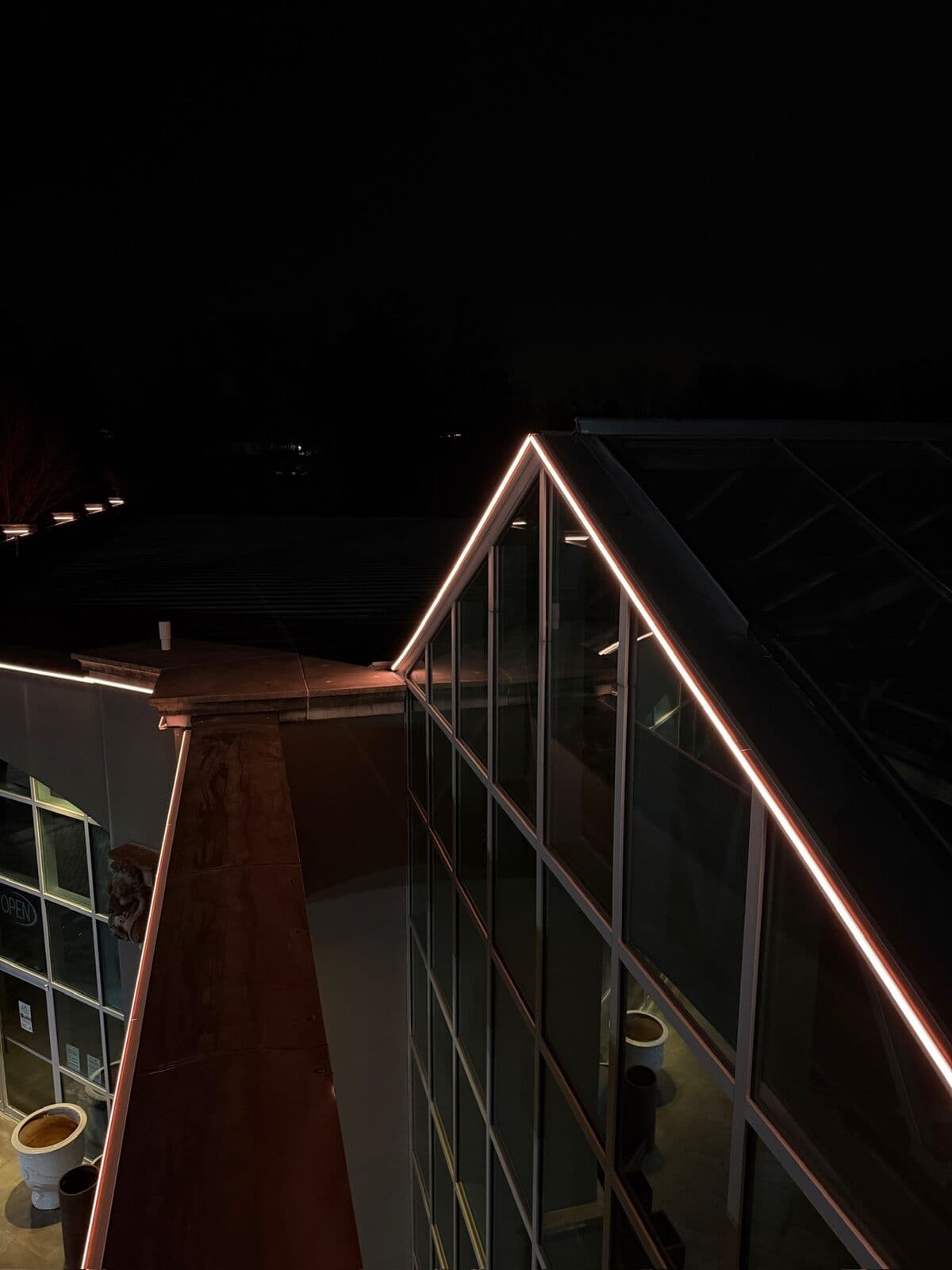 A lit warm white run following the rake of a gable and turning at the peak on an Omaha home