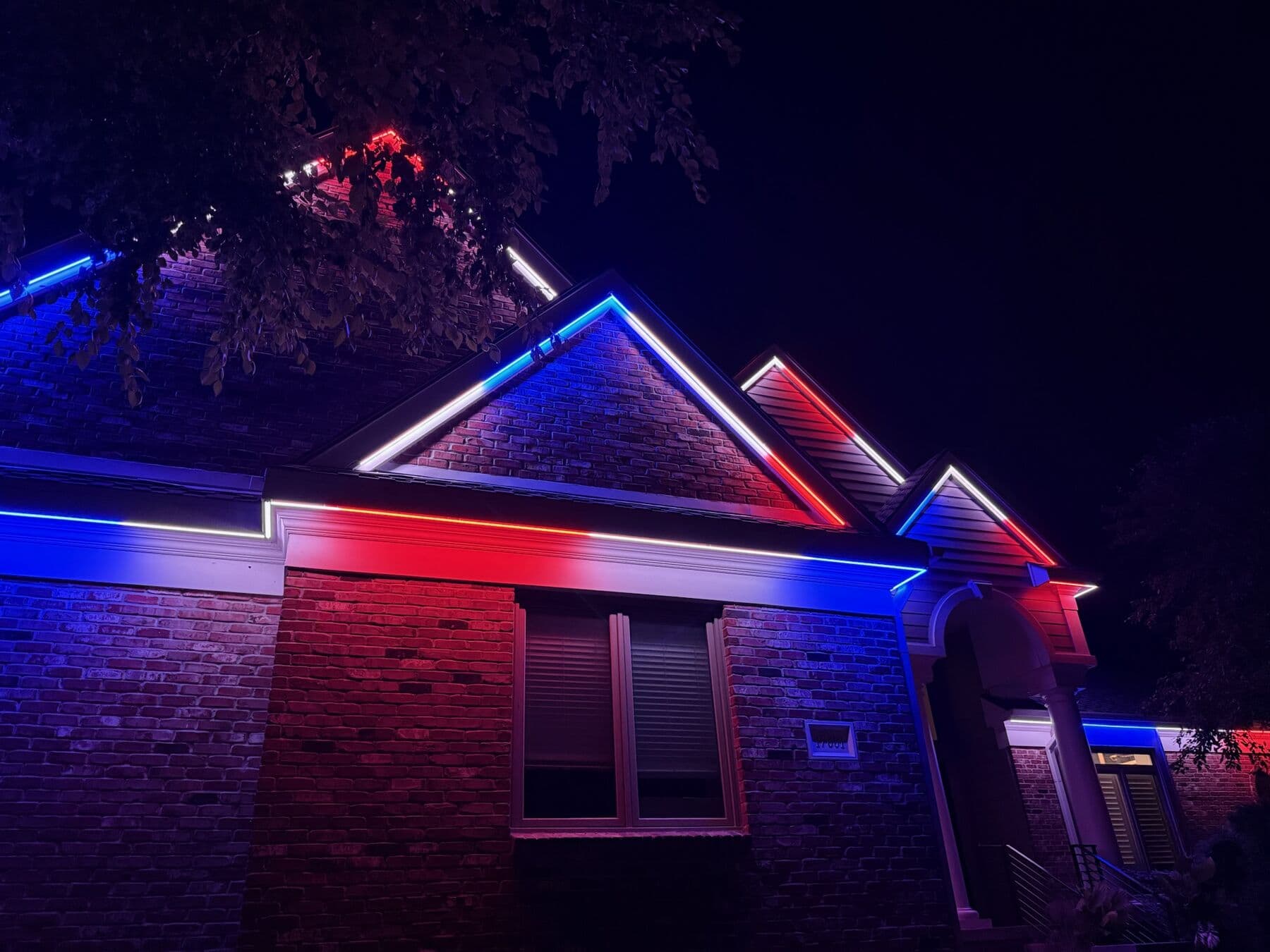 A brick Omaha ranch in red, white and blue among trees for the Fourth of July