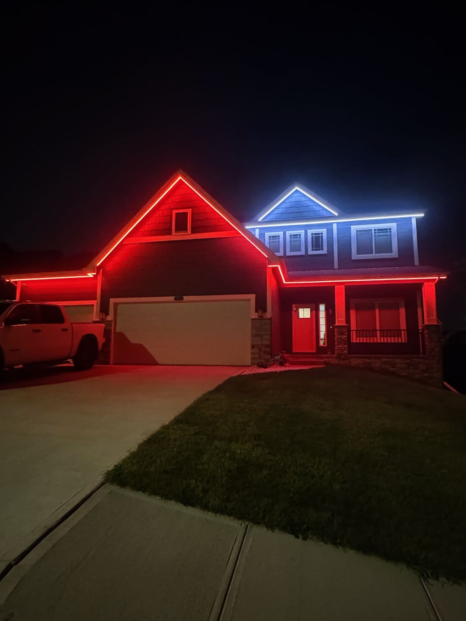 An Omaha home with the garage gable in red and the second gable in blue and white, a pickup in the drive