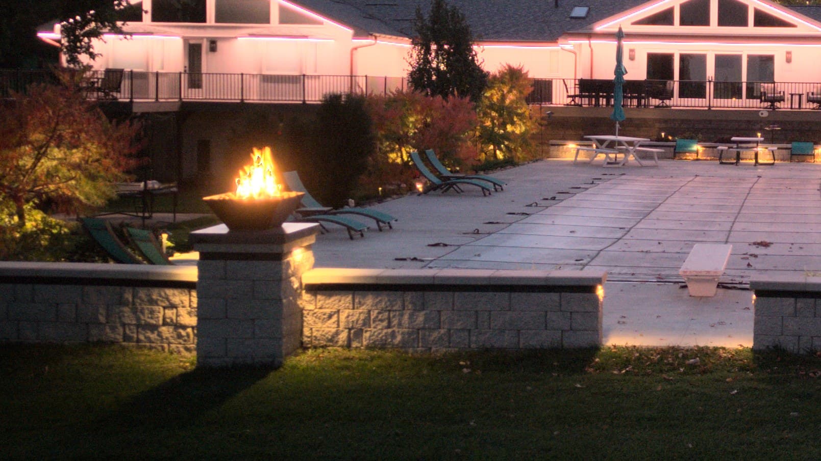 Hardscape lighting washing a limestone retaining wall and pool deck at an Omaha home