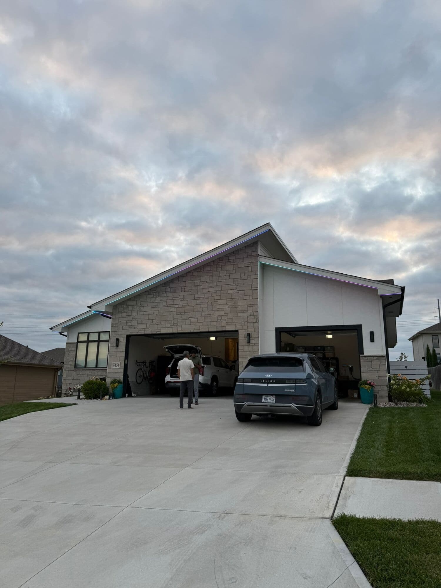 A daytime install at an Omaha home, the garage open and two people working at the front of the house
