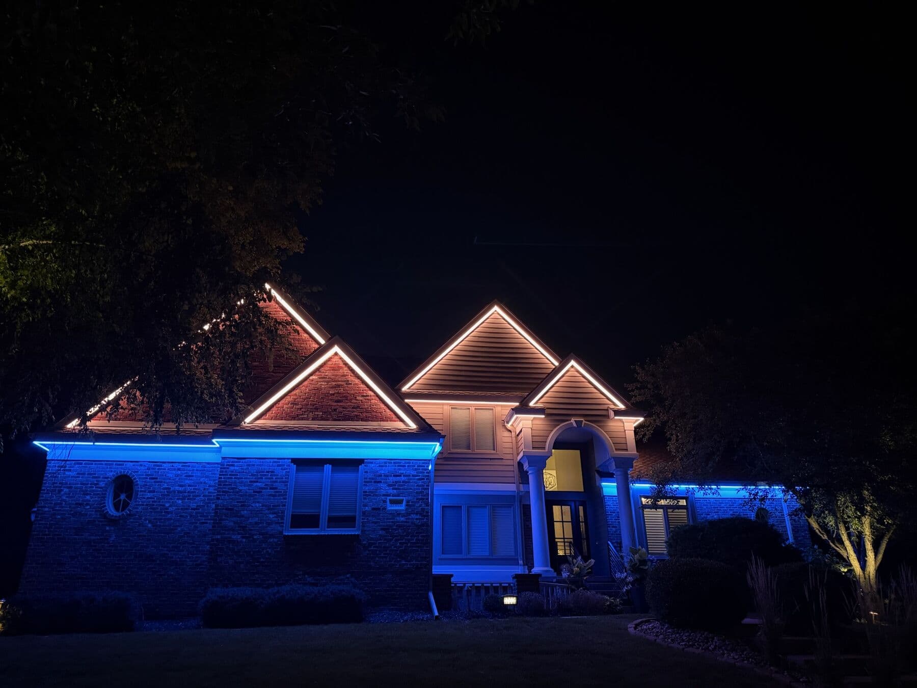 An Omaha home with the gables in warm white and the stone band below in blue