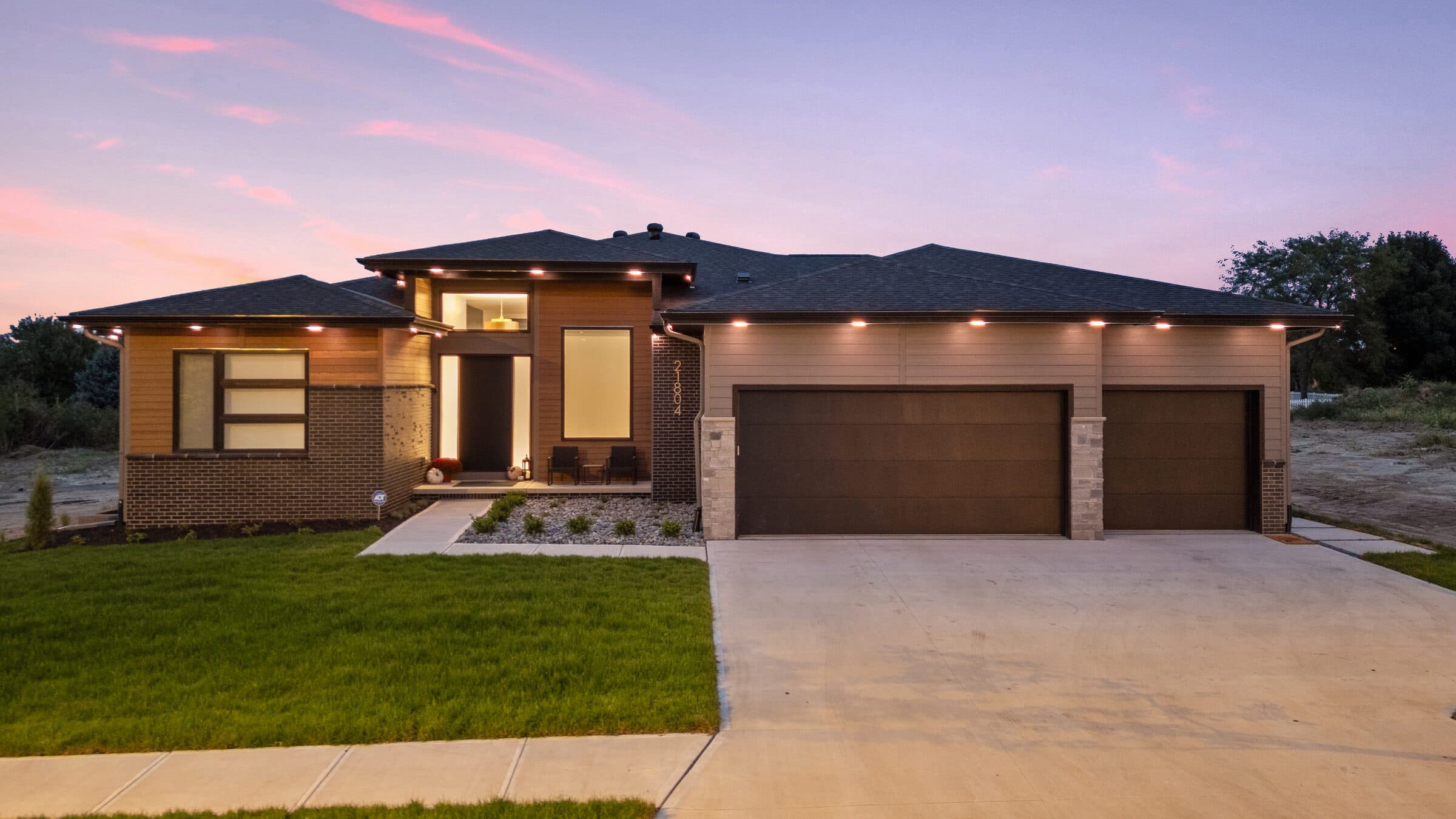 The same house minutes later with the run dimmed to a low warm white, enough to read the driveway by